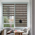 Brown zebra blinds above cozy reading chair in living room