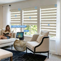Voice activated smart zebra shades in a contemporary living room, controlled via smart speaker with "Open the shades" command for natural lighting