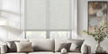 Light filtering roller shades in linen fabric over living room sofa, elegant neutral tone for modern home decor