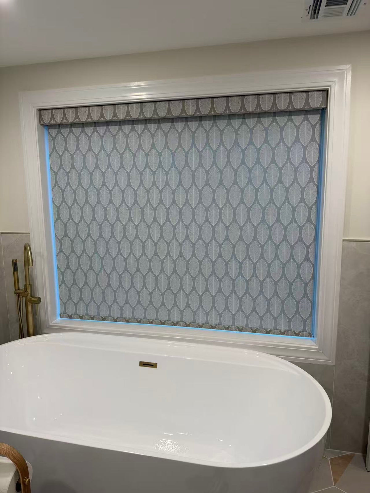 Patterned KALIA roller shade fitted above a freestanding bathtub